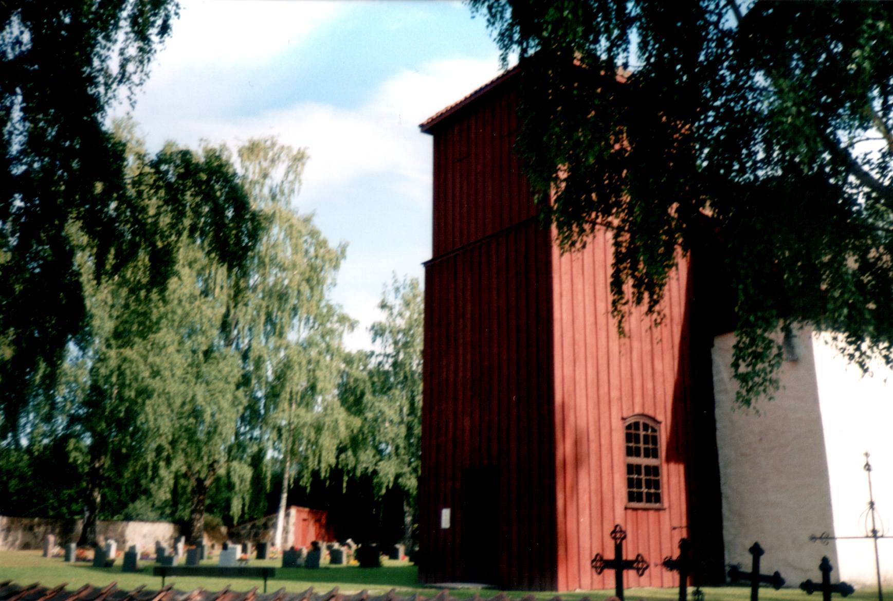 Romnes Kirke - trnfot med deler av kirkegrden p nordsiden - Tower with churchyard beyond.